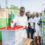 Romuald Wadagni participant au scrutin présidentiel au Bénin, entouré d'électeurs, lors du processus.